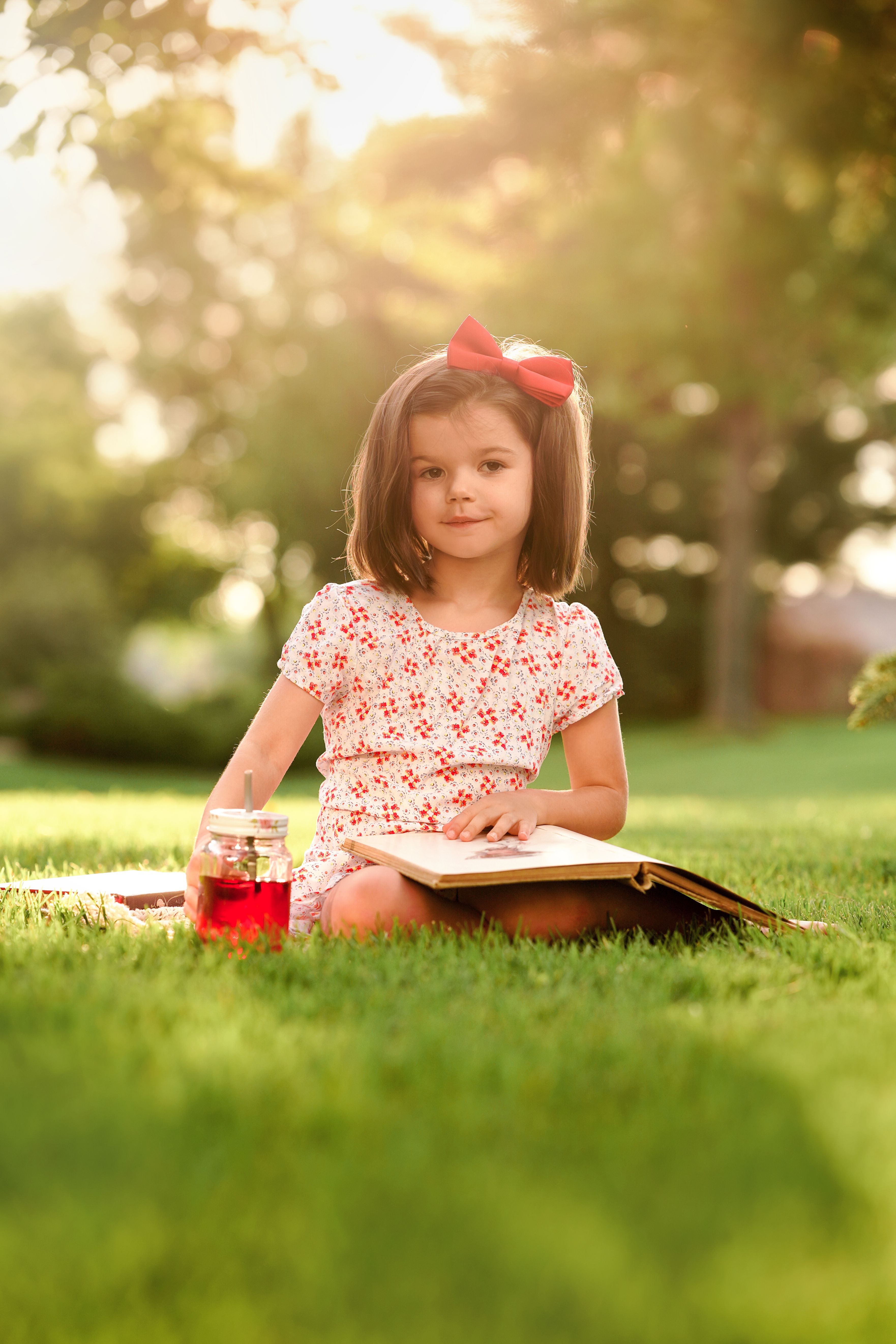 Girl in Pink Floral Shirt Sitting on Green Grass Field · Free Stock Photo