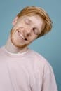 Man in Pink T-Shirt Smiling with Closed Eyes