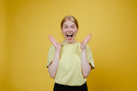 Woman in Yellow T-shirt and Black Pants Standing Excited with Open Mouth