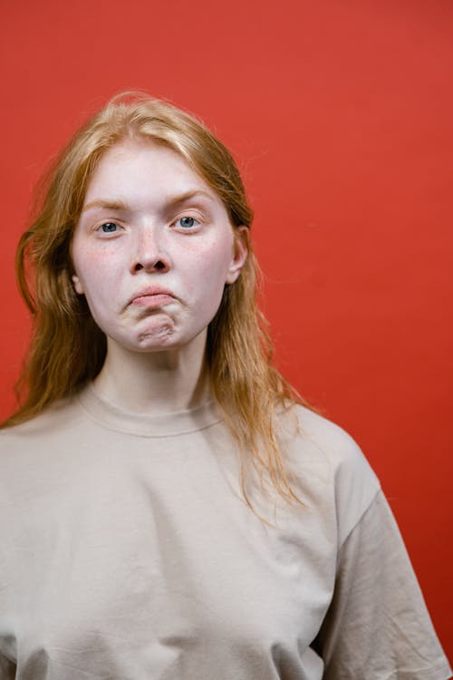 A Woman in Beige Shirt Looking with a Serious Face