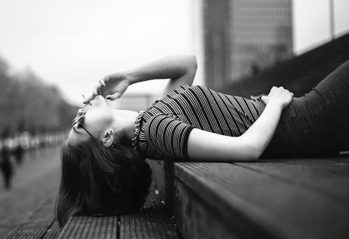 Woman Laying on Stairway Grayscale Photo