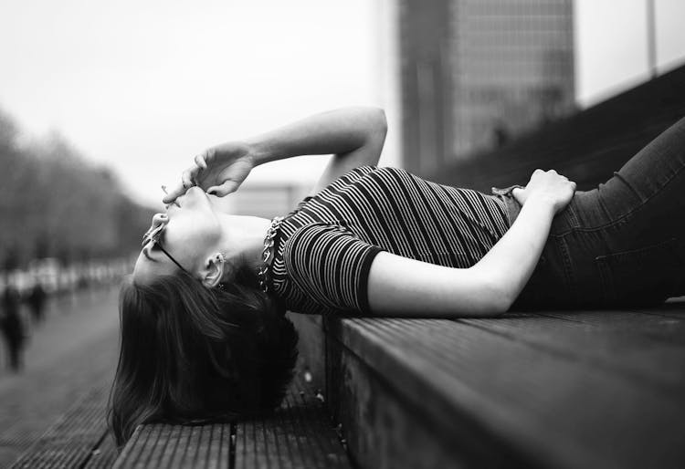 Woman Laying On Stairway Grayscale Photo