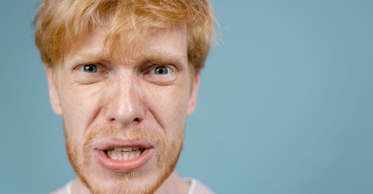 Close-up of a redhead man showing an intense facial expression against a blue background. - Evidence evidence guide for ginger memory meta-analysis