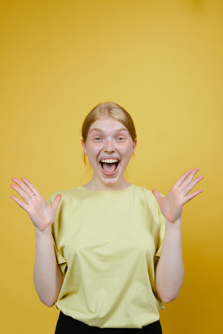  Smiling Woman In Yellow T-shirt Holding Hands Apart