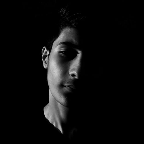 Free Dramatic black and white portrait of a man with half face in shadow, capturing a mysterious mood. Stock Photo