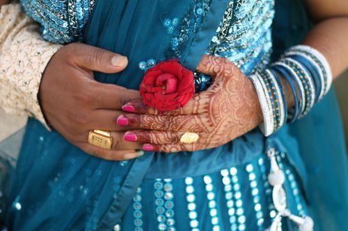 Free An Indian couple embraces with symbolic mehndi and vibrant attire, sharing love and tradition. Stock Photo