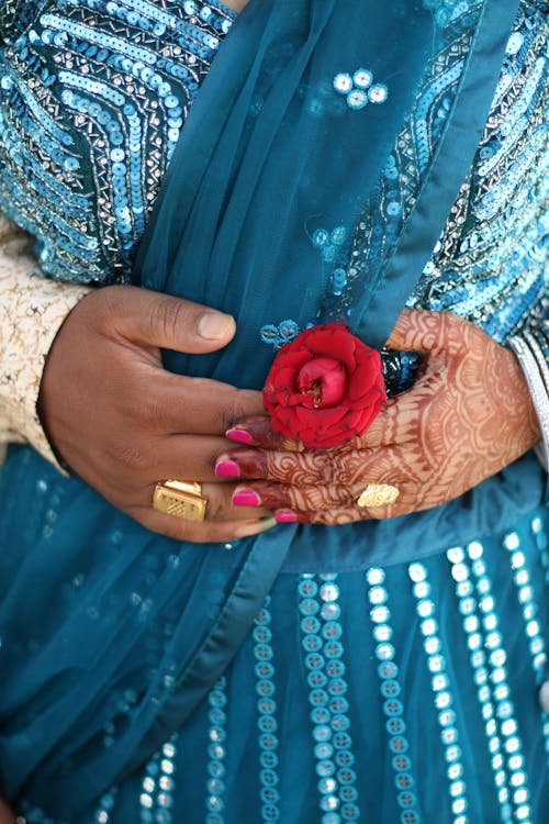 Man's and Woman's Hands with Red Rose on Blue Dress