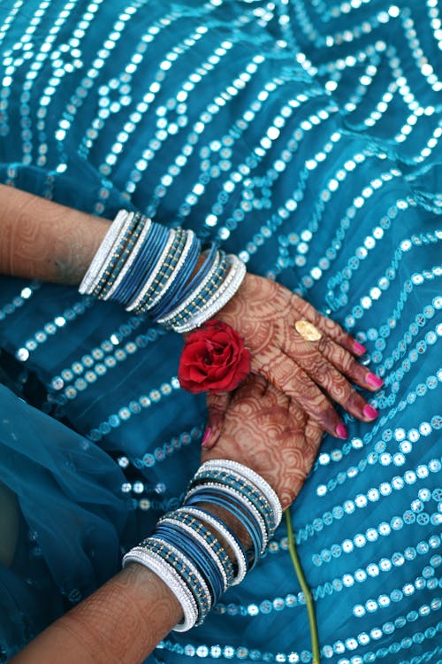 Free Woman's Hands with Henna Tattoos on Blue Dress Holding Red Rose Stock Photo