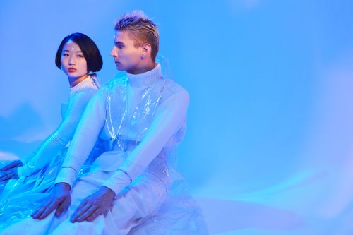 Free Contemporary studio portrait of a man and woman in futuristic white attire with blue lighting. Stock Photo
