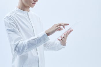 A Person in White Long Sleeves Holding a Clear Glass