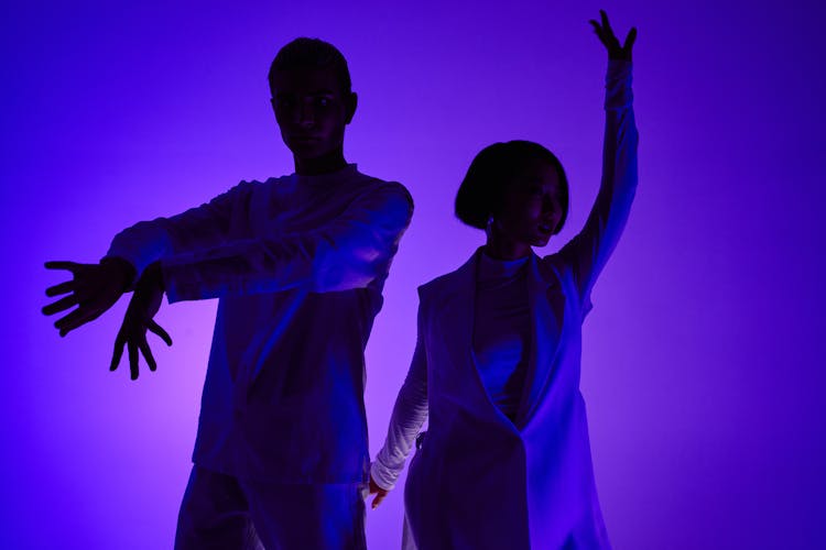 Man And Woman Doing Hand Movements On Blue Lighting 