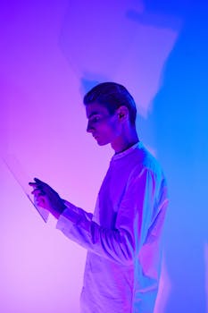 Caucasian man in a studio with vibrant lighting interacting with a digital interface.