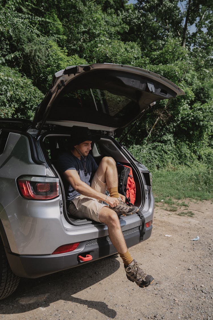 Man Sitting In The Trunk Of A Car