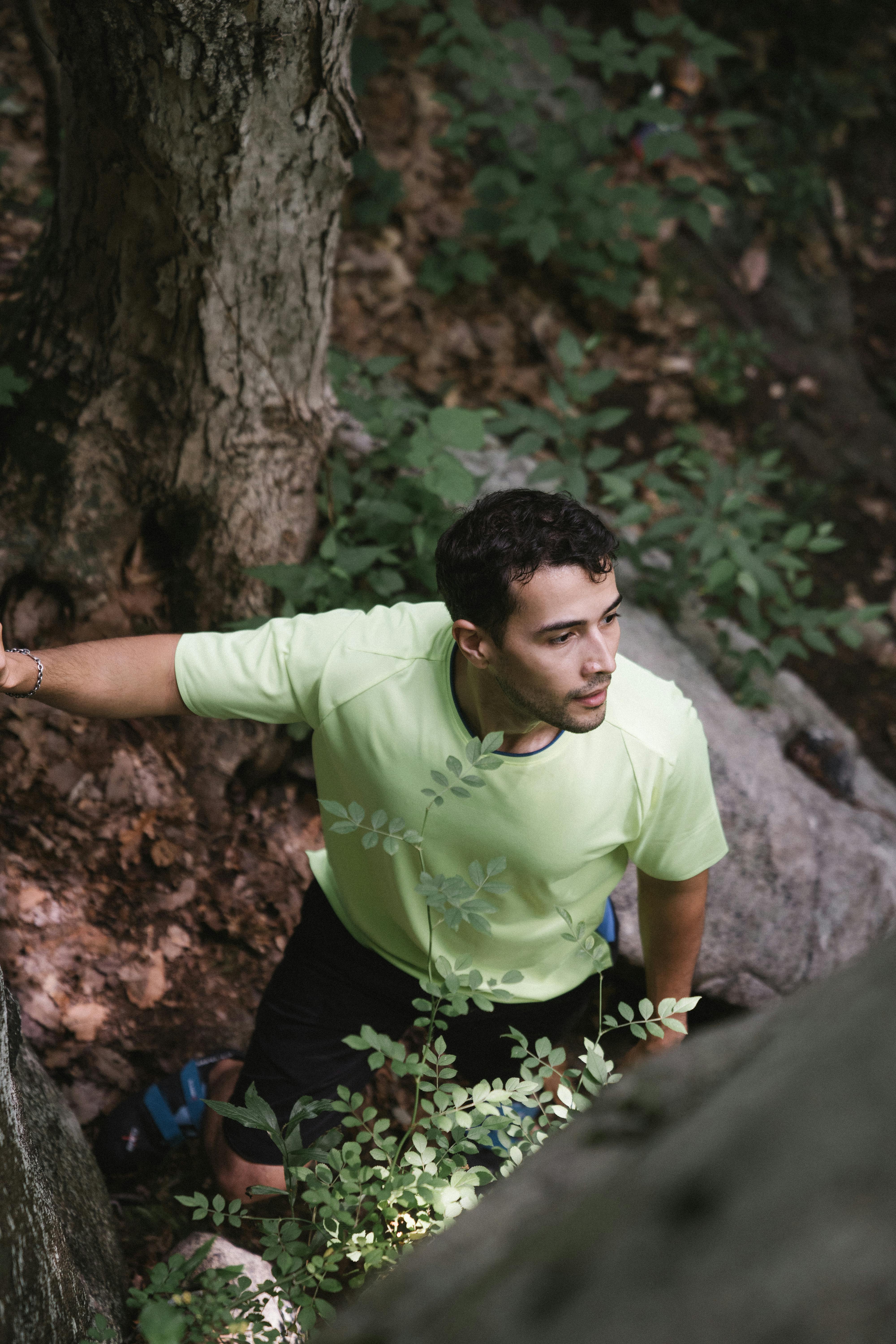 a man wearing a green shirt in a forest