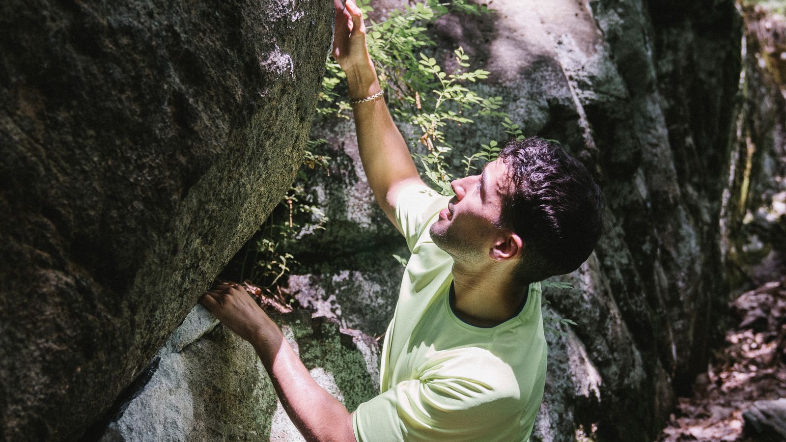 A climber pressing down on a large rounded sloping hold