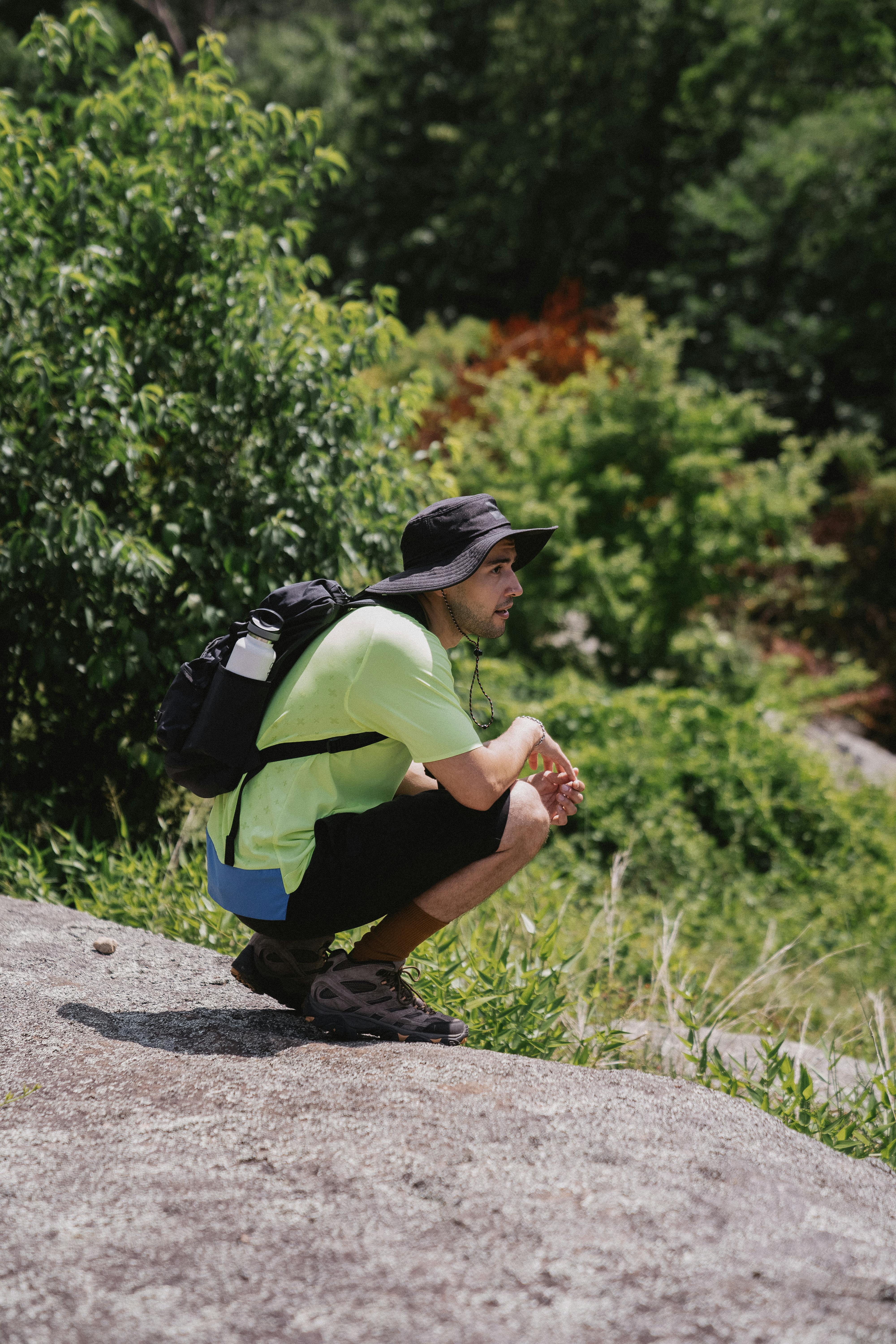 An adventurous hiker in outdoor gear exploring lush greenery during the day.
