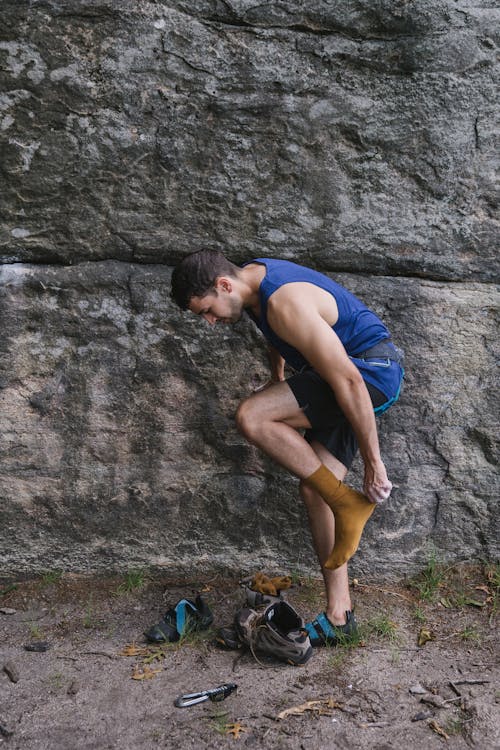 Climber Changing Shoes by a Rock