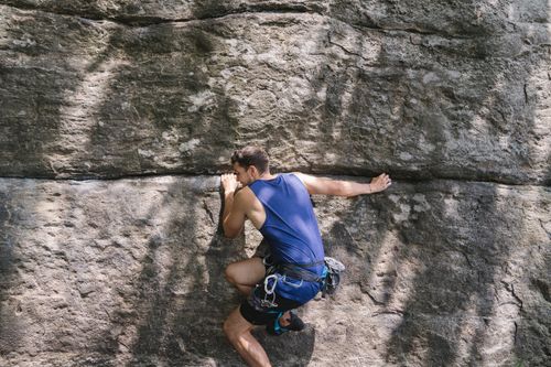 Free An adventurous man rock climbing a rugged cliff face outdoors, showcasing strength. Stock Photo