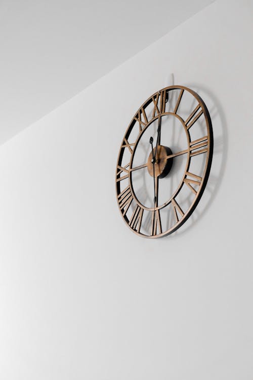 Free Gold Round Wall Clock on White Painted Wall Stock Photo