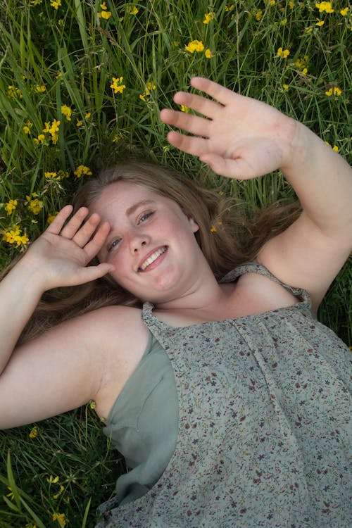 A Woman Smiling while Lying Down on the Grass