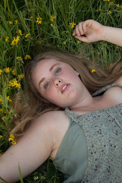 A Woman Lying on Green Grass Field