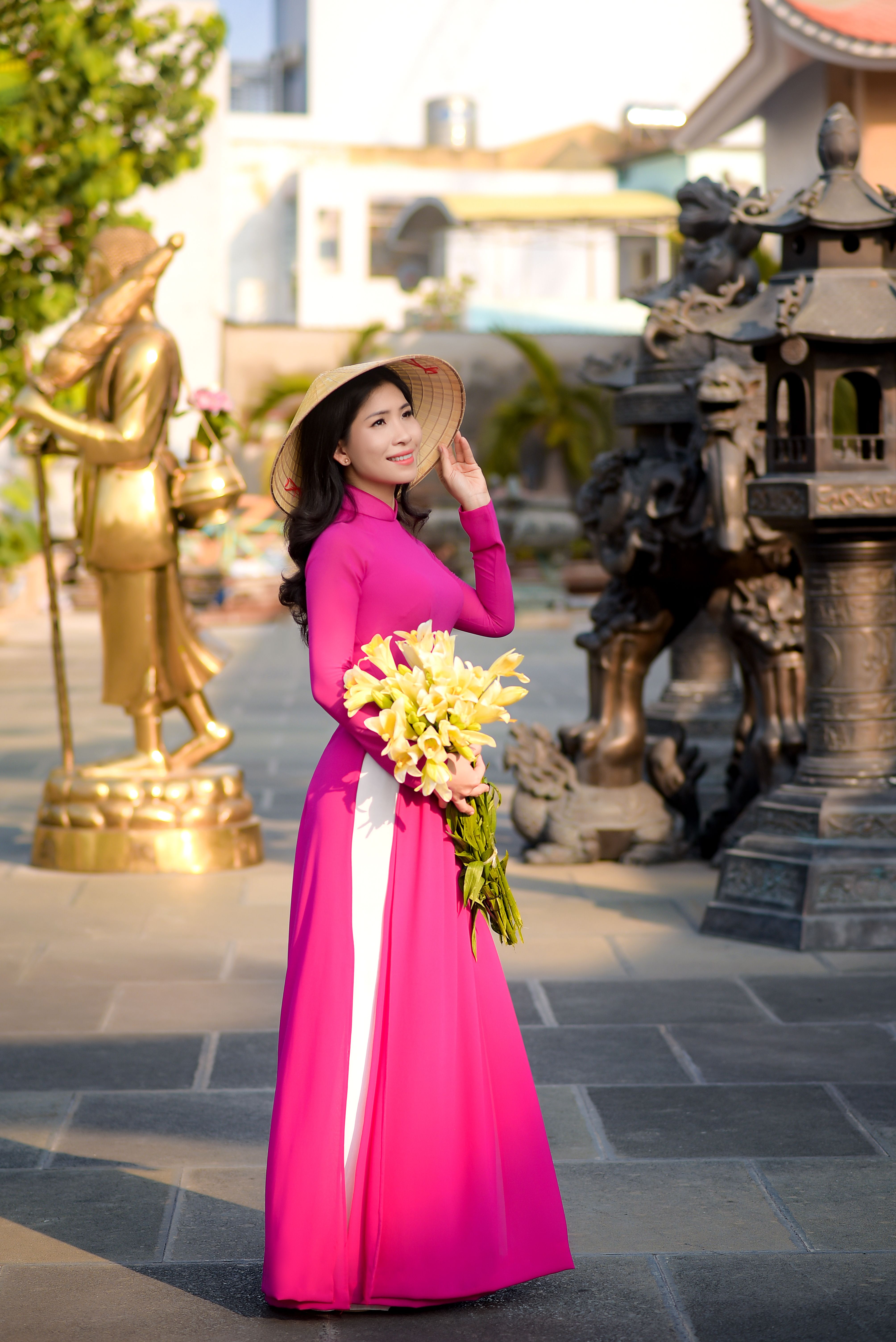 A Pretty Woman in Pink Dress Holding Yellow Flowers · Free Stock Photo