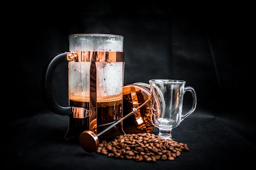 Coffee Beans Beside Coffee Press and Glass Cup