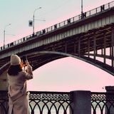 Person photographing a bridge at dusk — photo by Карина Лукашина on Pexels