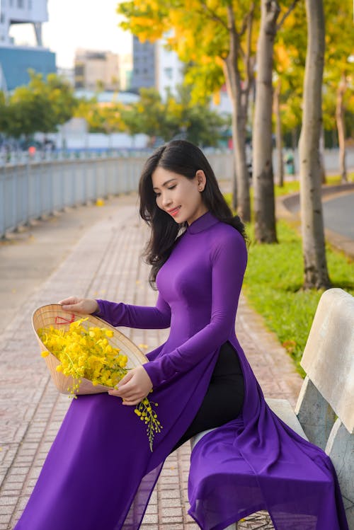 Free A Pretty Woman in Purple Dress Sitting on a Concrete Bench Stock Photo
