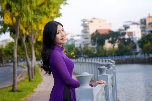 Free A Pretty Woman in Purple Dress Smiling Stock Photo