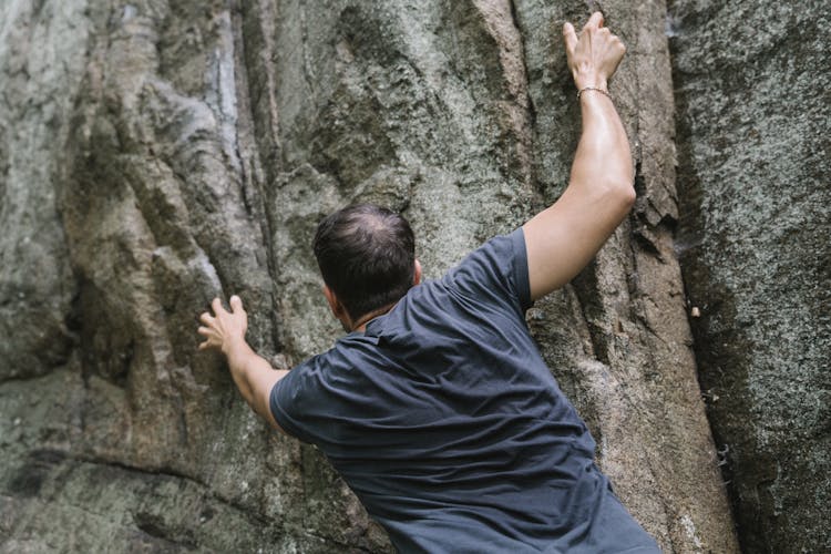 A Man Climbing A Rock