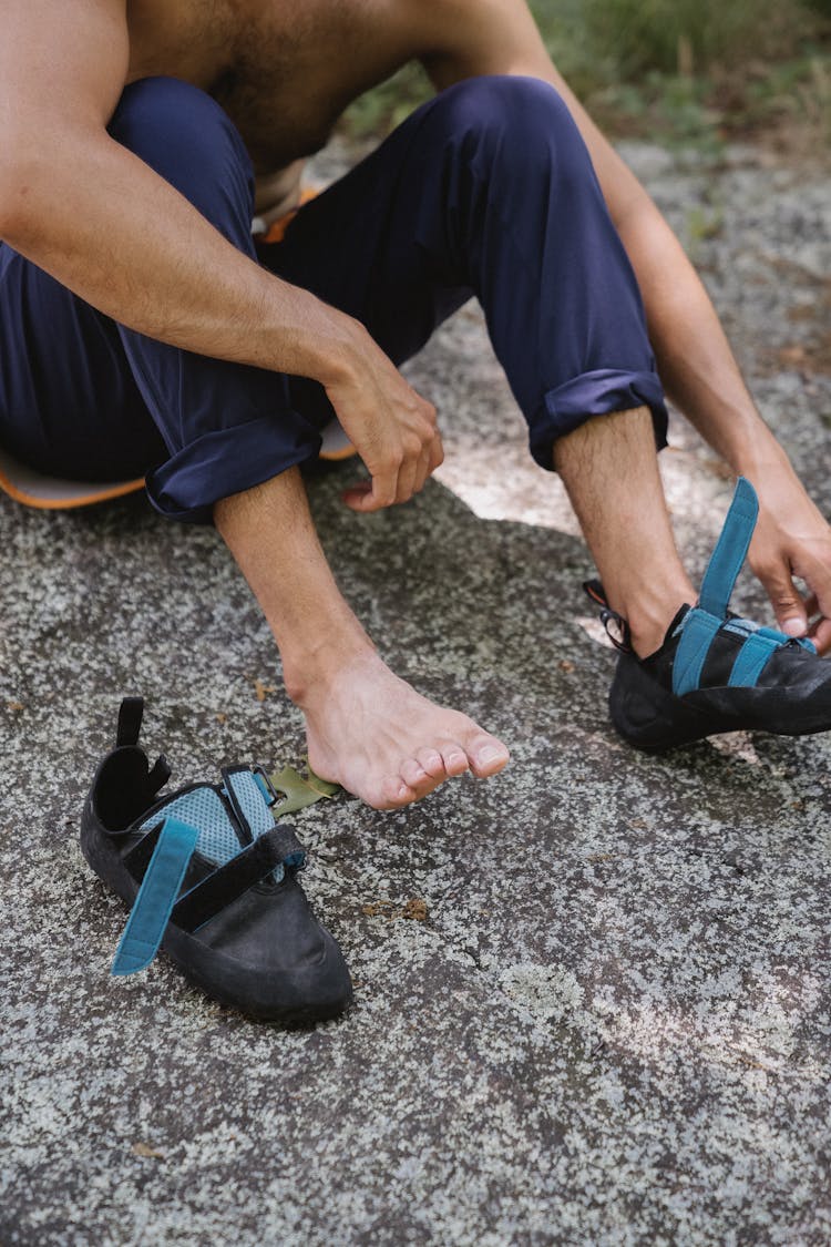 Man Sitting On Ground Wearing Hiking Shoes