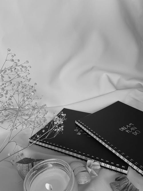 Free 

A Grayscale of Spiral Notebooks beside a Lighted Candle Stock Photo
