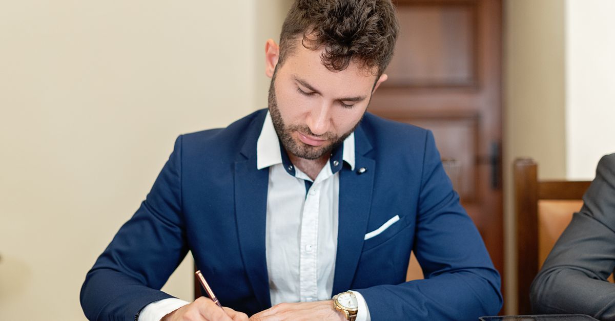 Hand signing the standard Ontario Form 401 residential tenancy agreement with pre-printed terms and a pen