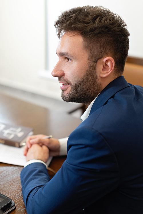 Free A focused businessman in a blue suit at work, sitting in an office meeting. Stock Photo