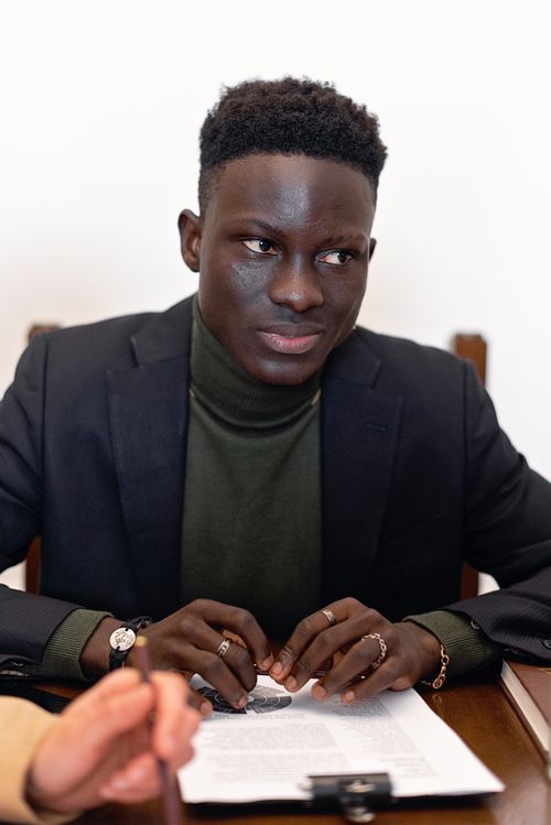 Free Confident young businessman at a meeting, focused on the discussion. Stock Photo