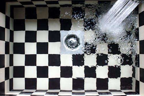 Water Flowing on White and Black Checked Bath Tub