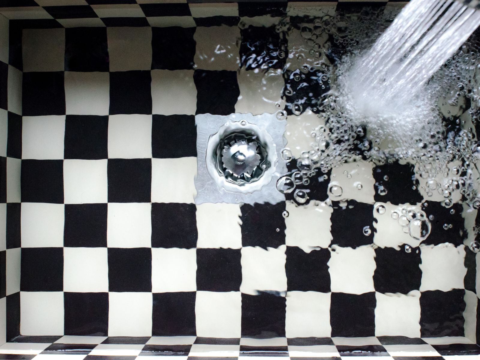 Water pooling in a kitchen sink, a sign of a slow or blocked drain