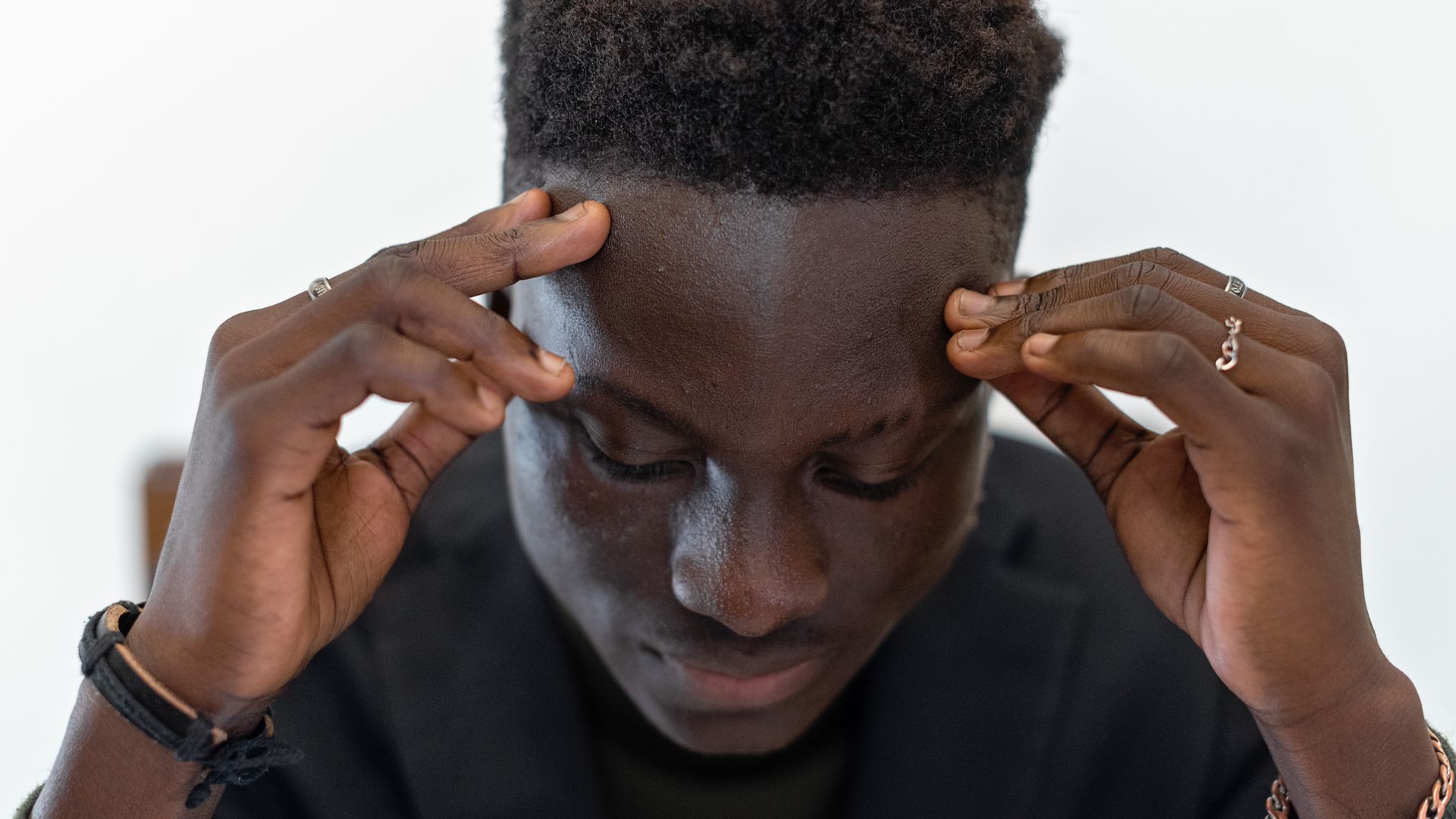Modafinil for Mental Clarity: Sharpen Your Mind Businessman in a suit concentrating, with focus on his expression and hands.