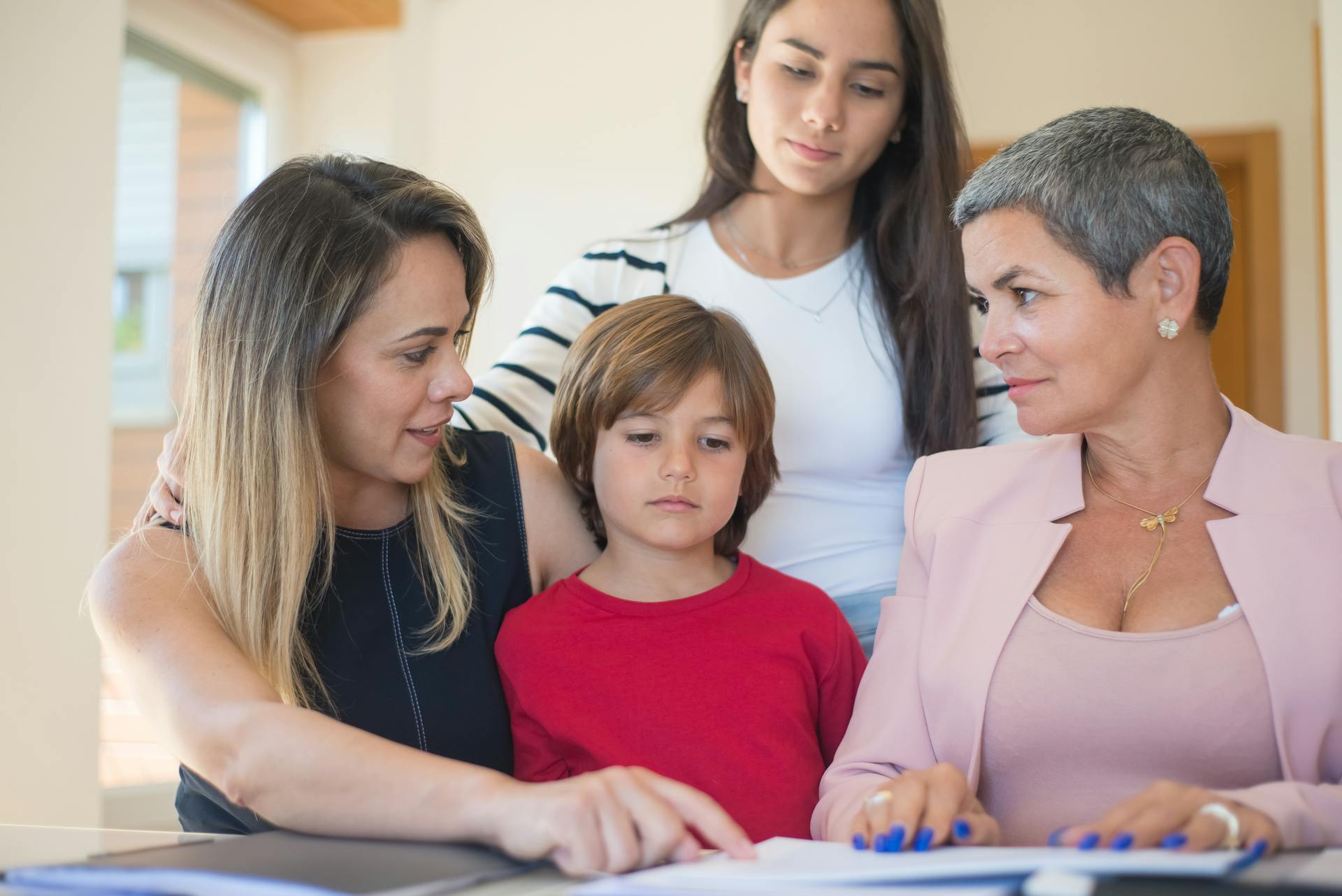 A family of four discussing real estate documents indoors with their realtor.