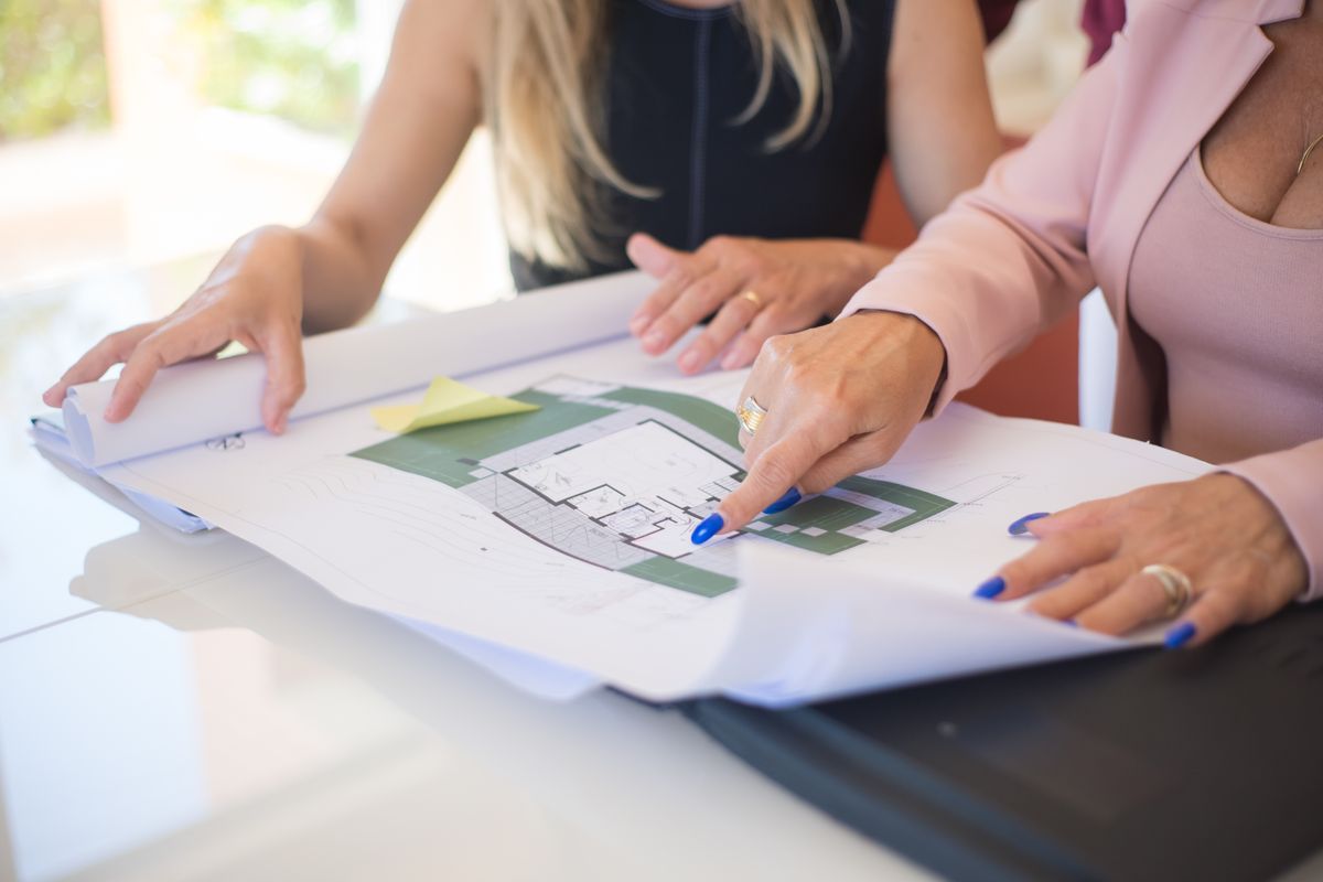 A construction team reviewing different project inquiries and documents around a meeting table