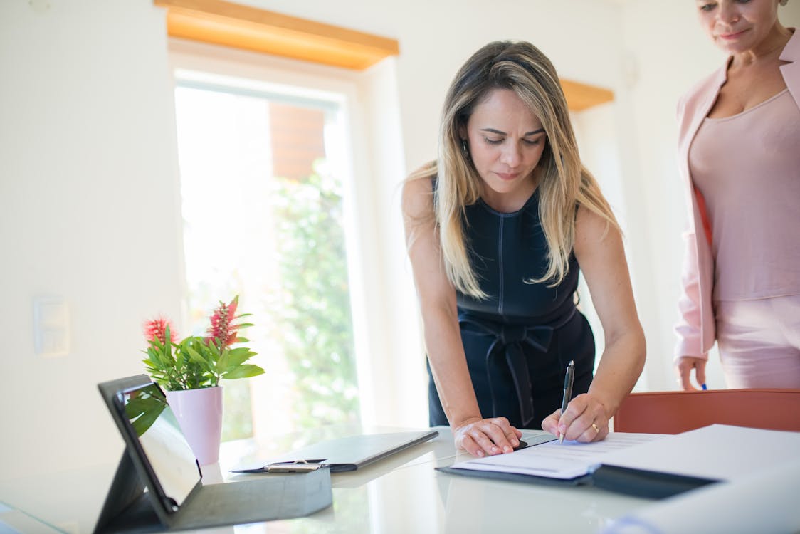 a woman signing a document.