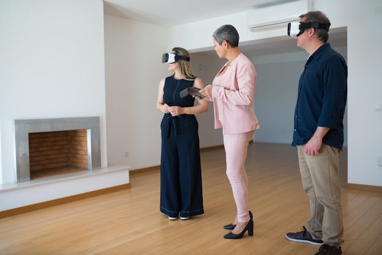 Real Estate Agent Showing A House To People Wearing Virtual Reality Goggles 