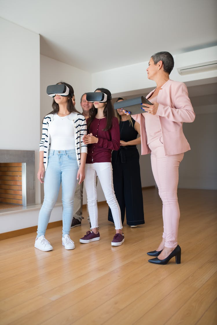 Real Estate Agent Showing A House To A Family Through Virtual Reality Goggles 