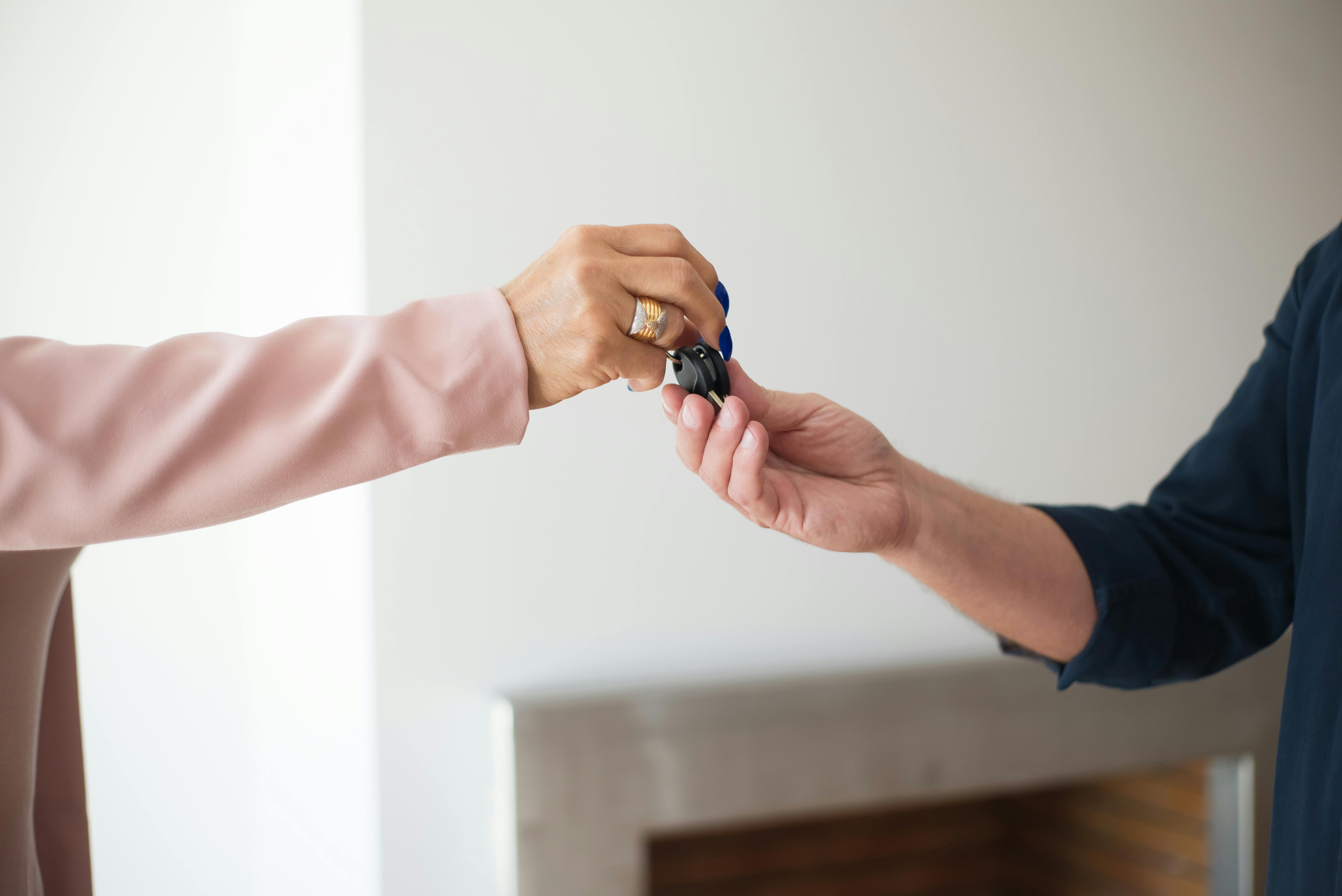 close up of person giving keys to another person