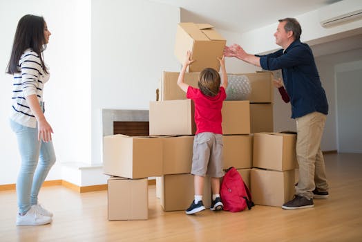 A family working together to move cardboard boxes inside their new home.