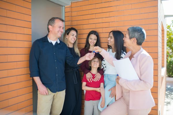 Real estate agent giving keys to happy family