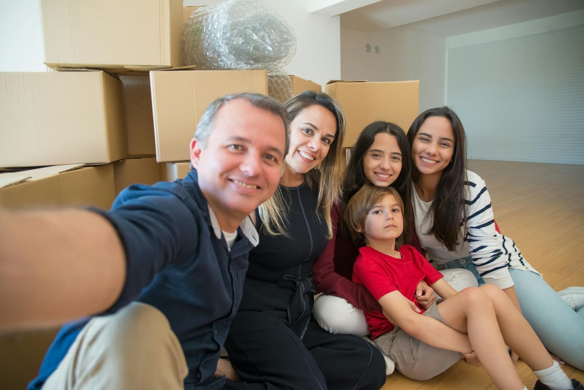 Almanya'da yeni bir hayata başlayan, ellerinde bavullarıyla gülümseyen mutlu bir aile ve çocukları.