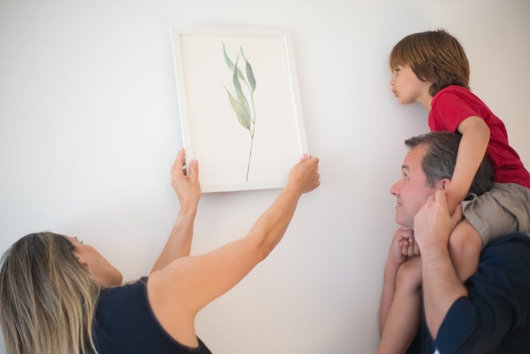 Woman Putting Wall Art On The Wall