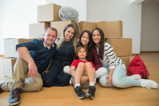 A joyful family sitting together with moving boxes in their new home.